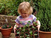 CHILD HOLDING ECHINACEA SEEDLINGS