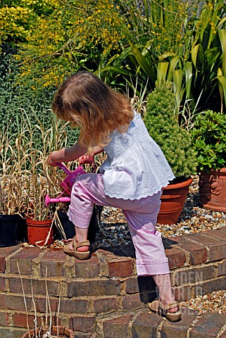 CHILD_WATERING_PLANT_IN_POT_WITH_A_WATERING_CAN__SURREY_LATE_JUNE