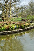 VIEW OF SEVEN ACRES LAKE WITH THE BICENTENARY GLASSHOUSE IN THE BACKGROUND. RHS WISLEY: APRIL