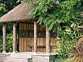 SUMMERHOUSE WITH WOOD DECORATION,  WEST DEAN GARDENS,  WITH TOONA,  BAMBOO & CORDYLINE
