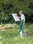 ARTIST AT WORK AMONGST TREES IN ARBORETUM