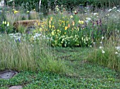 JORDANS WILDLIFE GARDEN DESIGNED BY SELINA BOTHAM. NATURAL PLANTING WITH SCULPTURED STRAW BENCH