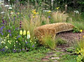 JORDANS WILDLIFE GARDEN DESIGNED BY SELINA BOTHAM. NATURAL PLANTING WITH SCULPTURED STRAW BENCH