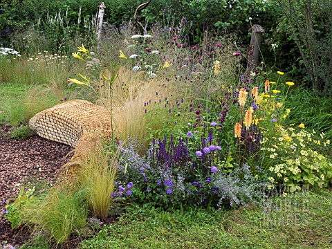 JORDANS_WILDLIFE_GARDEN_DESIGNED_BY_SELINA_BOTHAM_NATURAL_PLANTING_WITH_SCULPTURED_STRAW_BENCH