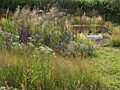 JORDANS WILDLIFE GARDEN DESIGNED BY SELINA BOTHAM. NATURAL PLANTING WITH SCULPTURED STRAW BENCH