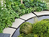 HOSTAS  BUXUS AND GRASSES PLANTED BESIDE A POND